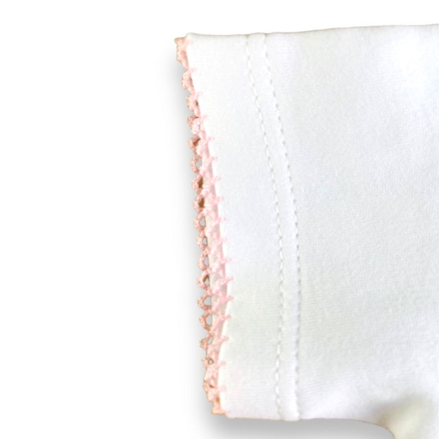 White baby vest with pink frilly collar. Close up of sleeve
