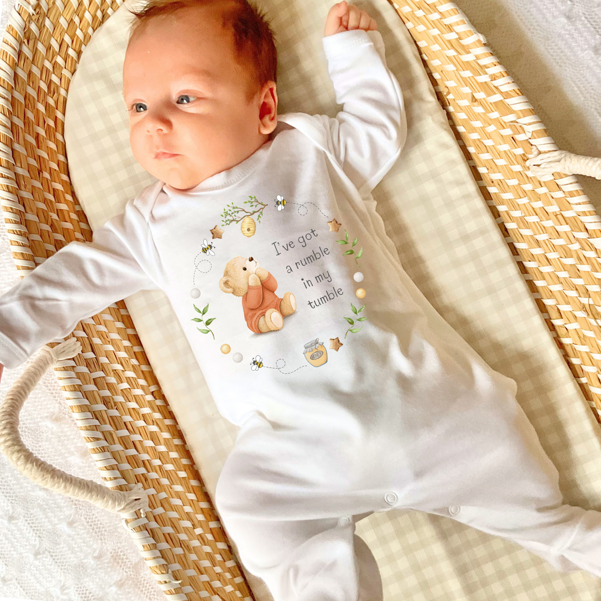 Baby wearing white Sleepsuit with "I've got a rumble in my tumble" Bear print on the front