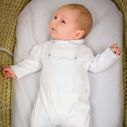 White sleep suit with grey polka dots. Front view on baby