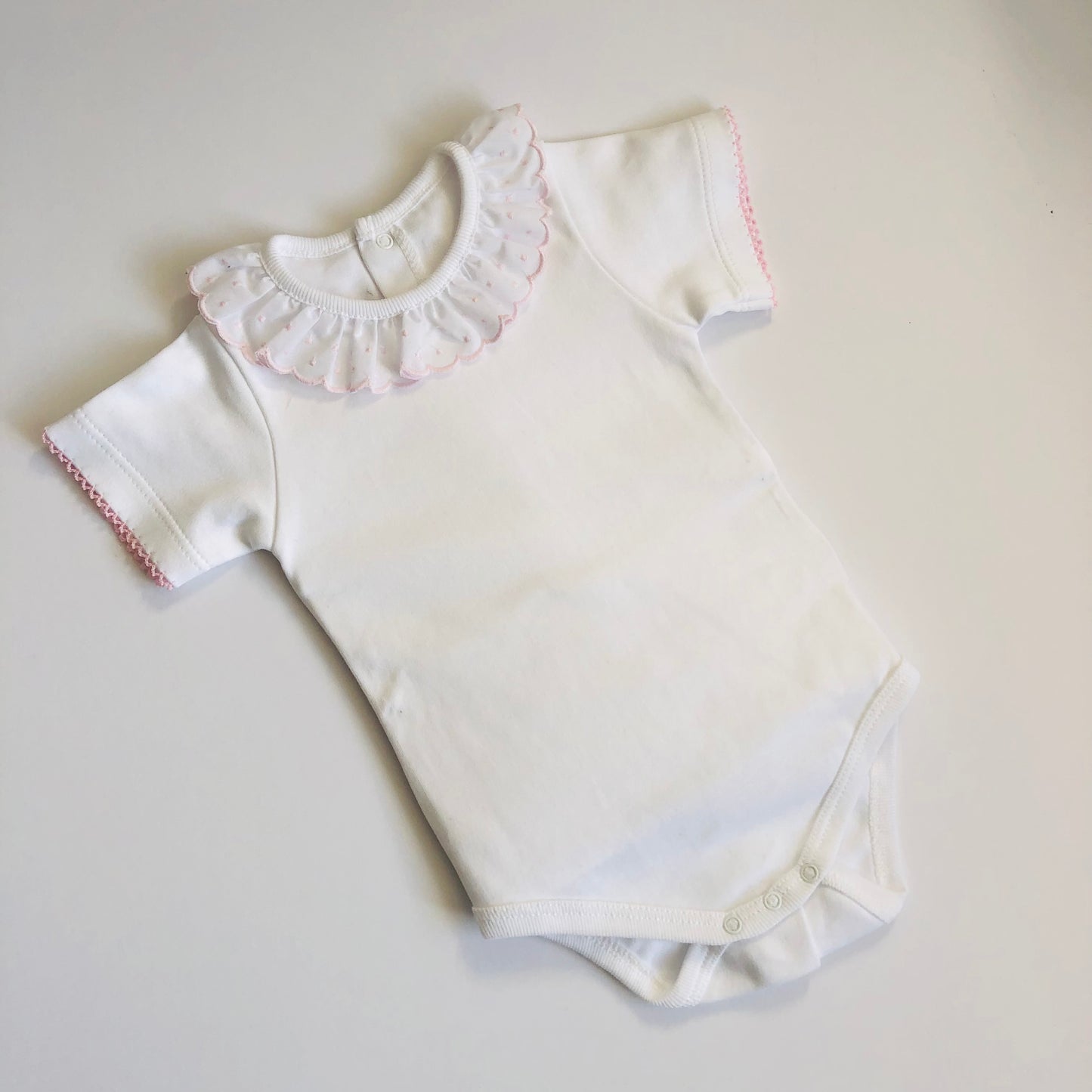 Baby vest with pink frilly collar