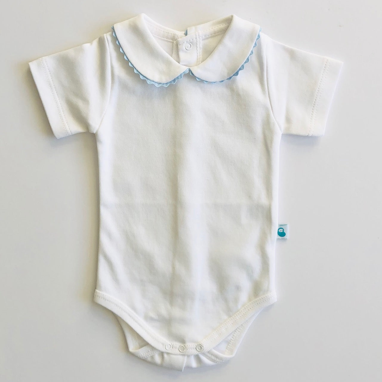 Baby vest with blue ric rac collar. Front view